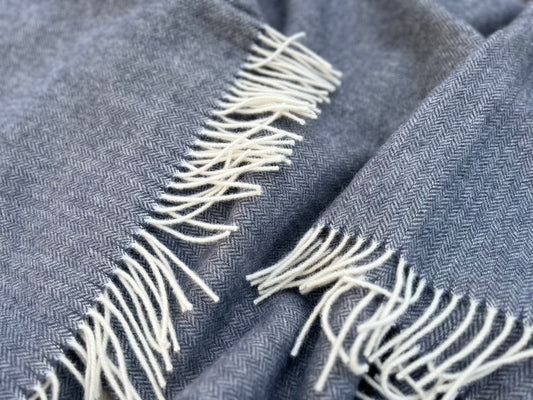 Wool balnket of a black-blue colour with white fringe edges