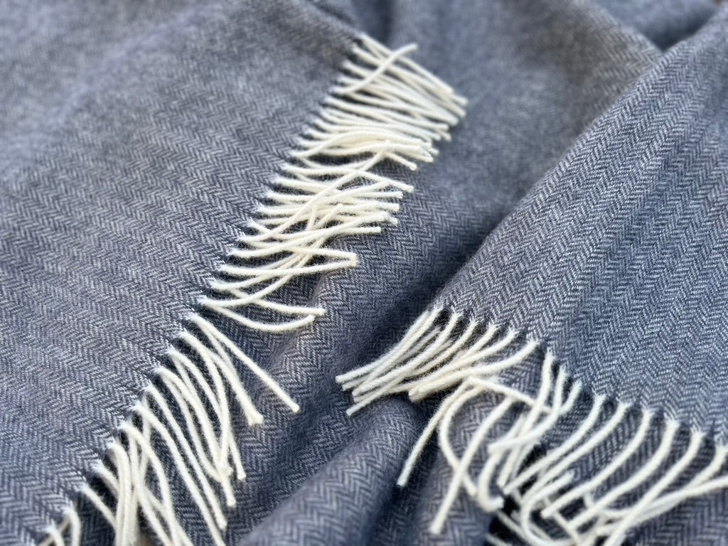 Wool balnket of a black-blue colour with white fringe edges