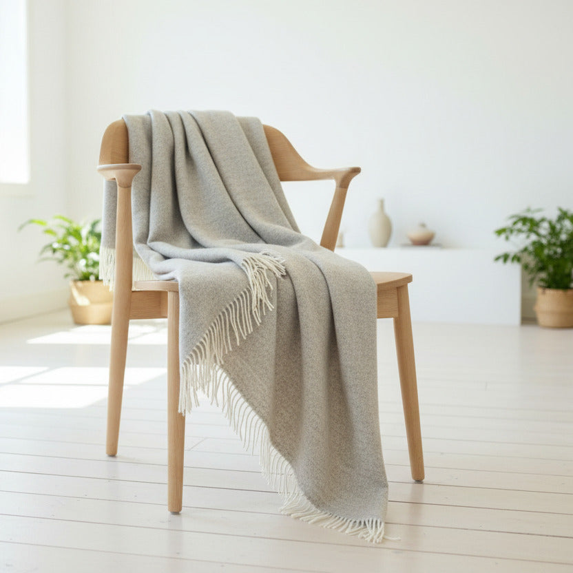 Beige wool throw draping from a wooden chair 