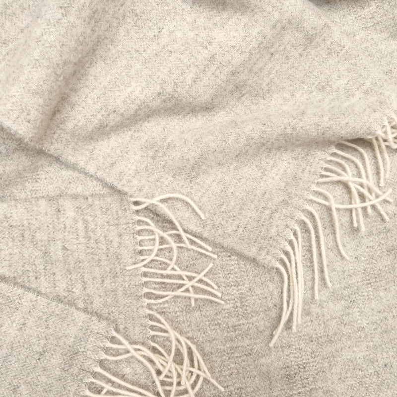 Beige wool blabket with herringbone pattern with white fringe
