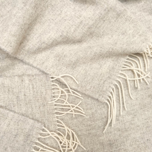 Beige wool blabket with herringbone pattern with white fringe